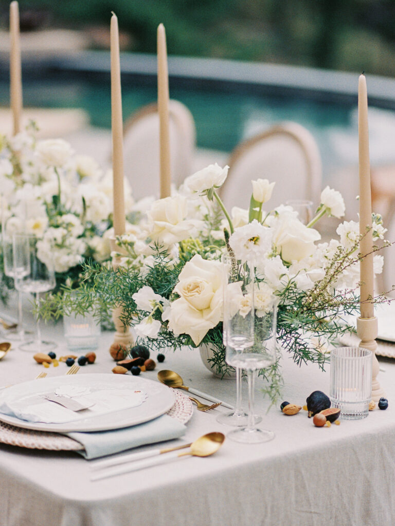 Ivory floral tablescape with taper candles and gold flatware
